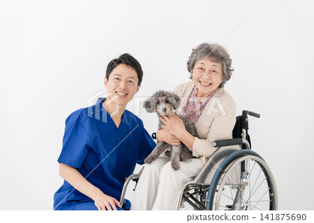 Senior woman in a wheelchair and therapy dog Senior woman in a wheelchair and therapy dog 141875690