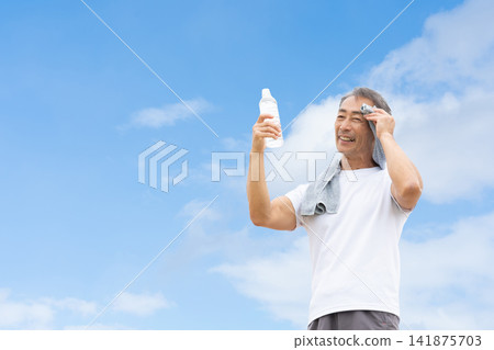 藍天下，男子正在喝水 141875703