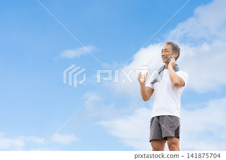 藍天下，男子正在喝水 141875704