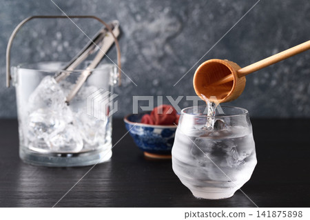 Pour shochu into a glass. 141875898