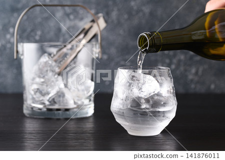 Pour shochu into a glass. Pour shochu into a glass. 141876011