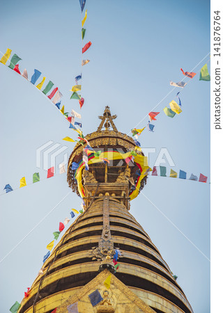 Vertical view of golden Swayambhunath stupa spire with prayer flags and sky copy space Vertical view of golden Swayambhunath stupa spire with prayer flags and sky copy space 141876764