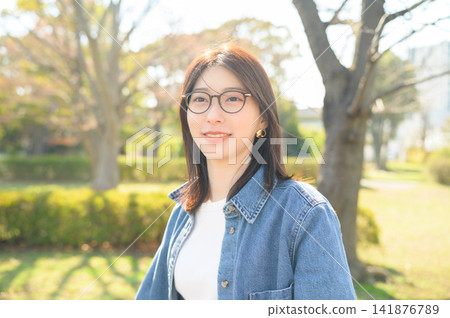 公園裡戴著眼鏡的日本女子 公園裡戴著眼鏡的日本女子 141876789
