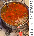Large pot of hot red borscht soup with herbs 141876877