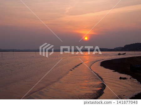 茨城縣日沼湖的日落。橙色的夕陽與漁船返航的剪影交相輝映,構成了一幅美麗而令人印象深刻的景象。 茨城縣日沼湖的日落。橙色的夕陽與漁船返航的剪影交相輝映,構成了一幅美麗而令人印象深刻的景象。 141877048