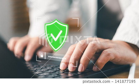 Businessman typing password on laptop with green shield check mark icon. Concept of cyber security, data protection, network safety, firewall encryption, and secure internet access Businessman typing password on laptop with green shield check mark icon. Concept of cyber security, data protection, network safety, firewall encryption, and secure internet access 141877195
