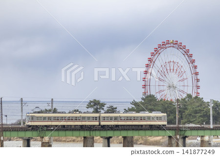 A local train crossing the Hayatsuki River and a Ferris wheel A local train crossing the Hayatsuki River and a Ferris wheel 141877249