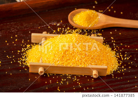fine yellow corn grits pile with a wooden spoon fine yellow corn grits pile with a wooden spoon 141877385