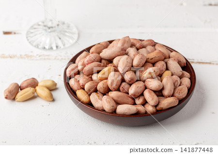 roasted salted peanuts with skin served on small dish roasted salted peanuts with skin served on small dish 141877448