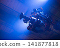 Professional movie camera on gimbal stabilizer rig with blue light copy space 141877818