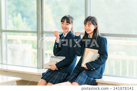 小學和國中女生在學校教室交談(握拳) 小學和國中女生在學校教室交談(握拳) 141878141