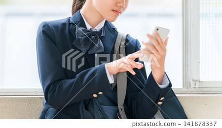 Smiling middle school and high school girls using smartphones in the school hallway (crime prevention, safety, security) Smiling middle school and high school girls using smartphones in the school hallway (crime prevention, safety, security) 141878337