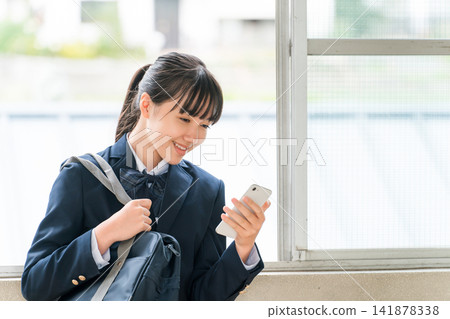 Smiling middle school and high school girls using smartphones in the school hallway (crime prevention, safety, security) Smiling middle school and high school girls using smartphones in the school hallway (crime prevention, safety, security) 141878338