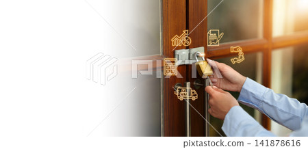 Cropped hands unlocking padlock on wooden door with business icons for success concept 141878616