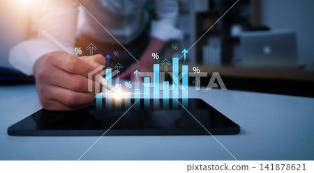 Businessman analyzing financial growth chart on digital tablet for business success Businessman analyzing financial growth chart on digital tablet for business success 141878621
