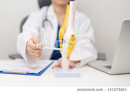 Doctor with Human Knee joint anatomy model. Osteoarthritis, Patellofemoral Pain Syndrome, Patellar Tendinitis, ACL, Anterior Cruciate Ligament, PCL, Posterior, MCL, Medial Collateral, LCL and Lateral Doctor with Human Knee joint anatomy model. Osteoarthritis, Patellofemoral Pain Syndrome, Patellar Tendinitis, ACL, Anterior Cruciate Ligament, PCL, Posterior, MCL, Medial Collateral, LCL and Lateral 141878861