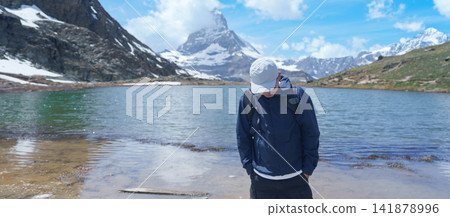 man Tourist Exploring Zermatt, Switzerland. happy hiker sightseeing iconic Matterhorn Swiss Alps at Riffelsee Lake, Famous European Landmark, Hiking Attraction and Travel Destination in Europe man Tourist Exploring Zermatt, Switzerland. happy hiker sightseeing iconic Matterhorn Swiss Alps at Riffelsee Lake, Famous European Landmark, Hiking Attraction and Travel Destination in Europe 141878996