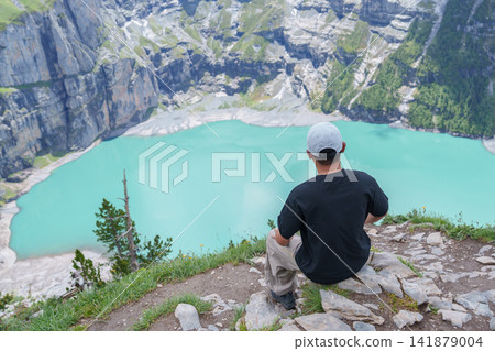 man Tourist Explore Oeschinensee, Kandersteg, Switzerland in Summer. Hiker Enjoy the Famous Turquoise Alpine Lake and Hiking Trail View, Popular Europe Tourist Attraction and Travel Destination man Tourist Explore Oeschinensee, Kandersteg, Switzerland in Summer. Hiker Enjoy the Famous Turquoise Alpine Lake and Hiking Trail View, Popular Europe Tourist Attraction and Travel Destination 141879004