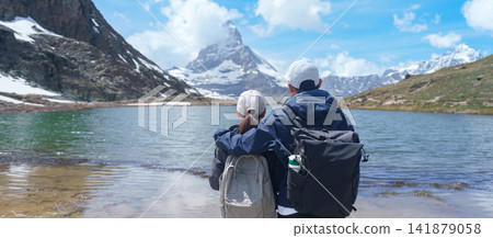 Couple Tourist Exploring Zermatt, Switzerland. happy hiker sightseeing iconic Matterhorn Swiss Alps at Riffelsee Lake, Famous European Landmark, Hiking Attraction and Travel Destination in Europe Couple Tourist Exploring Zermatt, Switzerland. happy hiker sightseeing iconic Matterhorn Swiss Alps at Riffelsee Lake, Famous European Landmark, Hiking Attraction and Travel Destination in Europe 141879058