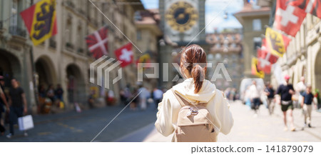 Woman Tourist Exploring Bern, Switzerland. Traveler Visit Kramgasse, Bern Old Town and the Zytglogge Clock Tower, Famous European Landmark, Popular Tourist Attraction and Travel Destination in Europe Woman Tourist Exploring Bern, Switzerland. Traveler Visit Kramgasse, Bern Old Town and the Zytglogge Clock Tower, Famous European Landmark, Popular Tourist Attraction and Travel Destination in Europe 141879079
