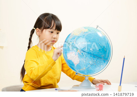 Asian little girl looking at globe, studying geography, focused child learning world map, education concept Asian little girl looking at globe, studying geography, focused child learning world map, education concept 141879719