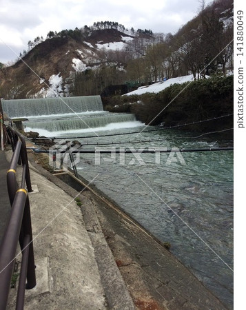 A landscape of Hijiori, Okura Village, Yamagata Prefecture, with snow-capped mountains and flowing snowmelt water. A landscape of Hijiori, Okura Village, Yamagata Prefecture, with snow-capped mountains and flowing snowmelt water. 141880049
