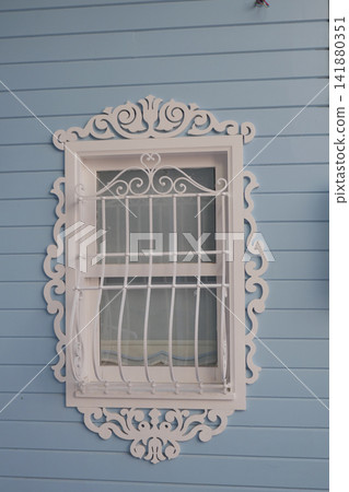 Window with decorative grill on blue wooden wall Window with decorative grill on blue wooden wall 141880351