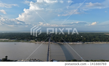 Drone view of Horipur Bridge extending across the wide Padma River with green riverbanks and surrounding rural landscape in Bangladesh. Drone view of Horipur Bridge extending across the wide Padma River with green riverbanks and surrounding rural landscape in Bangladesh. 141880769