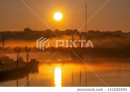 The rising sun shrouded in morning mist. The rising sun shrouded in morning mist. 141880999