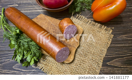Traditional smoked sausage with fresh dill and tomatoes on a rustic wooden table. Traditional smoked sausage with fresh dill and tomatoes on a rustic wooden table. 141881177