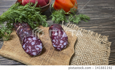 Traditional smoked sausage with fresh dill and tomatoes on a rustic wooden table. Traditional smoked sausage with fresh dill and tomatoes on a rustic wooden table. 141881192