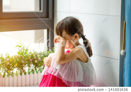 Sad and lonely little girl sitting on the floor in the corner looking depressed Sad and lonely little girl sitting on the floor in the corner looking depressed 141881636