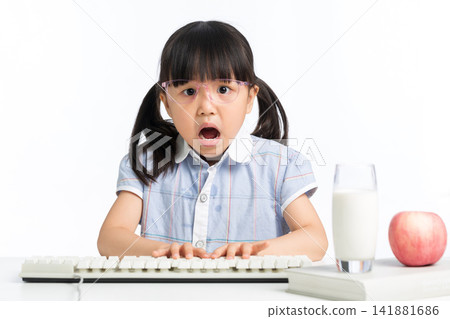 Surprised girl with open mouth using computer keyboard on desk 141881686