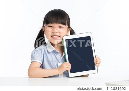 Happy girl student showing blank digital tablet screen for mockup Happy girl student showing blank digital tablet screen for mockup 141881692