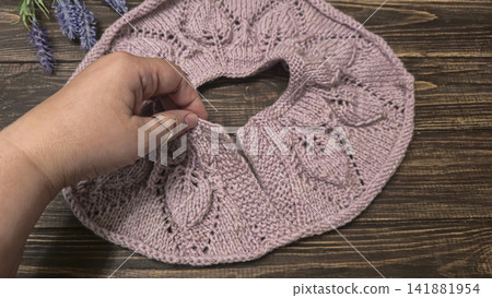 Knitted sweater collar in progress, using knitting needles and stitch markers. Knitted sweater collar in progress, using knitting needles and stitch markers. 141881954