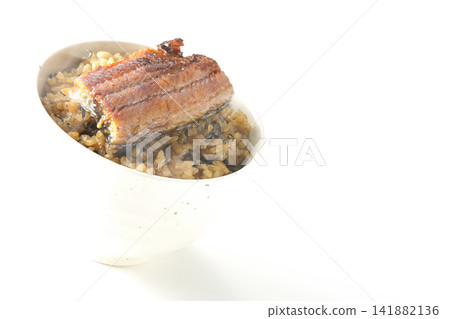 A piping hot mini eel rice bowl photographed alone against a white background. A piping hot mini eel rice bowl photographed alone against a white background. 141882136