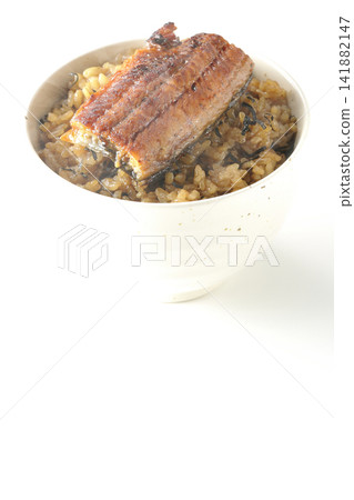 A piping hot mini eel rice bowl photographed alone against a white background. A piping hot mini eel rice bowl photographed alone against a white background. 141882147