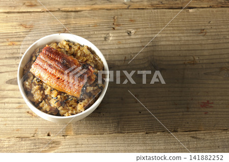 A single photo of a piping hot mini eel rice bowl. 141882252