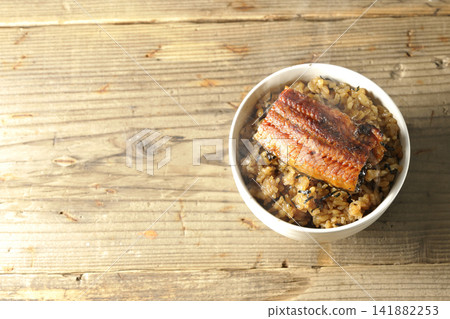 A single photo of a piping hot mini eel rice bowl. 141882253