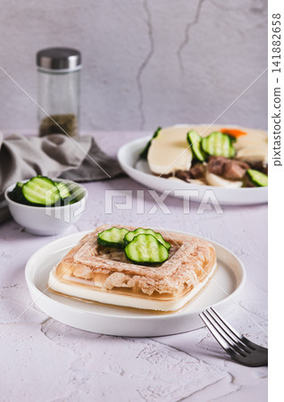 Delicious jellied chicken with mayonnaise on a plate on the table vertical view Delicious jellied chicken with mayonnaise on a plate on the table vertical view 141882658