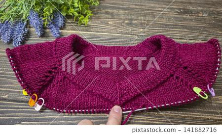 Knitted sweater collar in progress, using knitting needles and stitch markers. Knitted sweater collar in progress, using knitting needles and stitch markers. 141882716