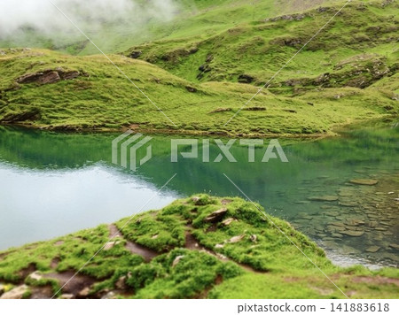 The crystal-clear waters and the emerald green waters of Bachalpsee in the Swiss Alps. The crystal-clear waters and the emerald green waters of Bachalpsee in the Swiss Alps. 141883618