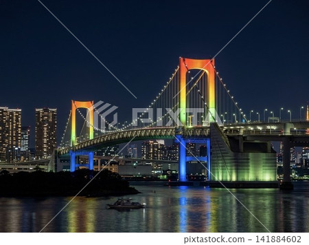 The Rainbow Bridge, specially lit up in rainbow colors, and the night view reflected on the surface of Tokyo Bay. The Rainbow Bridge, specially lit up in rainbow colors, and the night view reflected on the surface of Tokyo Bay. 141884602