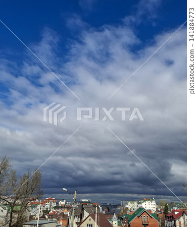 Scenic view of colorful town house roofs against blue and grey sky with clouds Scenic view of colorful town house roofs against blue and grey sky with clouds 141884773