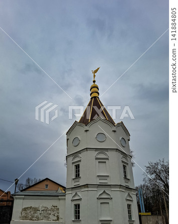White octagonal bell tower of Holy Trinity Convent in Zadonsk with a golden angel under a cloudy sky White octagonal bell tower of Holy Trinity Convent in Zadonsk with a golden angel under a cloudy sky 141884805