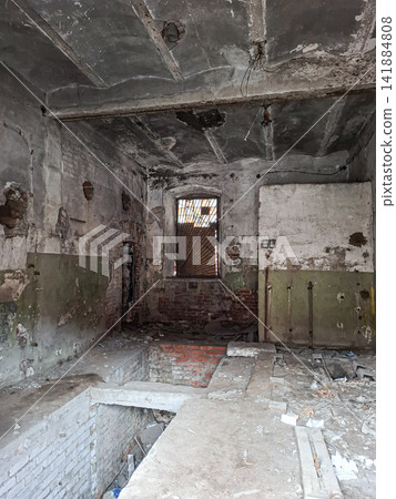 Creepy atmosphere inside an abandoned brick building with concrete floors and a barred window Creepy atmosphere inside an abandoned brick building with concrete floors and a barred window 141884808