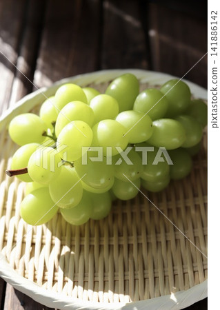 美味但略帶瑕疵的 Shine Muscat 葡萄盛放在竹篩上。 美味但略帶瑕疵的 Shine Muscat 葡萄盛放在竹篩上。 141886142