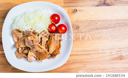 一道套餐式菜餚，包括薑汁豬肉炒菜和高麗菜絲。 141886534