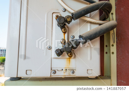 Outdoor Air Conditioning Unit with Water Dripping from Pipe Fittings Outdoor Air Conditioning Unit with Water Dripping from Pipe Fittings 141887057