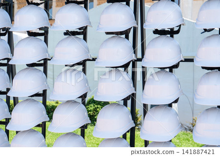 White Construction Hard Hats helmet on a Storage Rack for Safety and Protection at Industrial Work White Construction Hard Hats helmet on a Storage Rack for Safety and Protection at Industrial Work 141887421